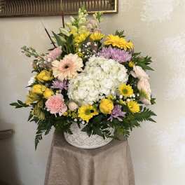 Mixed pastel flower arrangement in a white ceramic vase