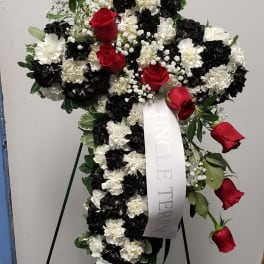Standing floral cross with red roses and black-and-white carnations