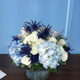 White roses and blue hydrangeas in a glass vase