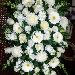White funeral spray with daisies, roses, and chrysanthemums
