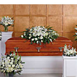 White floral funeral arrangements around a casket