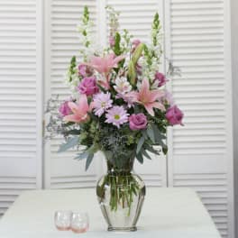 Pink lilies and roses in a clear glass vase