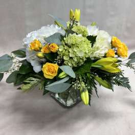 Yellow roses and white hydrangeas in a glass vase