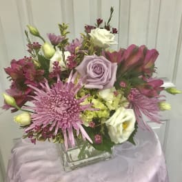 Bouquet of pink and white flowers in a square glass vase