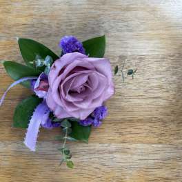 Lavender rose boutonniere with purple filler and ribbon