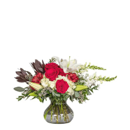 Bouquet of red roses and white lilies in a glass vase
