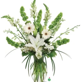 Tall white and green flower arrangement with lilies and gerbera daisies in a clear glass vase