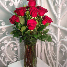 Red roses arranged in a clear glass vase