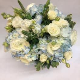 Bouquet of white roses and pale blue hydrangeas with green accents