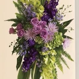 Tall purple and green floral spray on a white easel