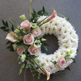 Circular floral wreath with white chrysanthemums, pale pink roses, and calla lilies