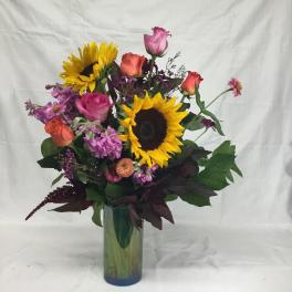 Bouquet of sunflowers and roses in a glass vase