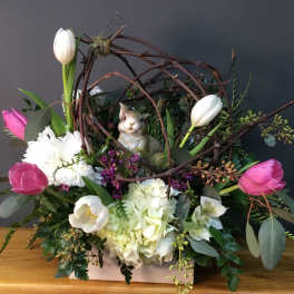 Floral arrangement with pink and white tulips, white blooms, and a rabbit figurine