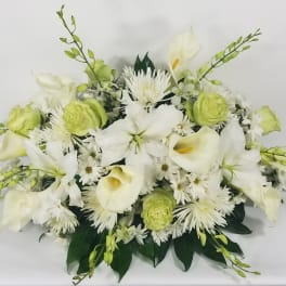 White calla lilies and green blooms in a low floral arrangement