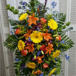 Large standing floral spray with orange lilies and yellow daisies