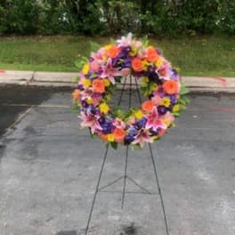 Colorful floral wreath on a metal stand outdoors