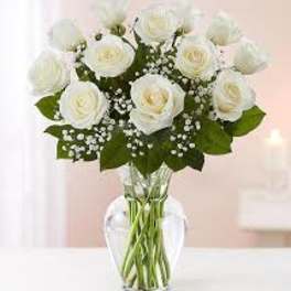 White roses arranged in a clear glass vase