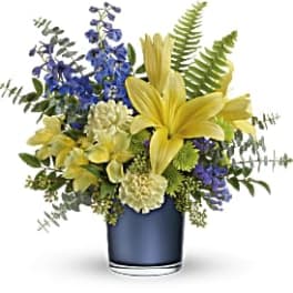 Yellow lilies and blue flowers in a blue vase