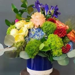 Colorful mixed flower arrangement in a blue ceramic vase