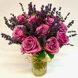 Pink roses with purple filler flowers in a glass vase