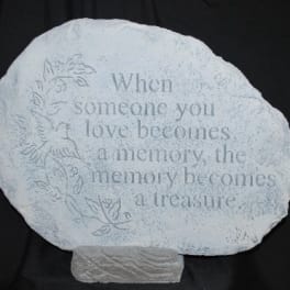 Decorative memorial stone with an engraved quote and floral border