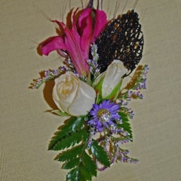 Boutonniere with pink and white flowers and a black decorative accent