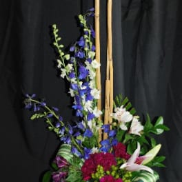 Tall floral arrangement with blue and white flowers and bamboo sticks