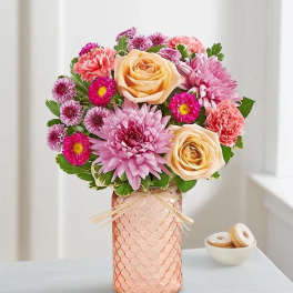 Pink and peach flower arrangement in a textured vase