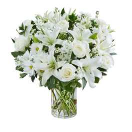 White lilies, roses, and daisies arranged in a clear glass cylinder vase
