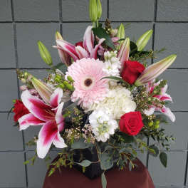 Mixed bouquet with pink lilies, red roses, and a pale pink gerbera daisy