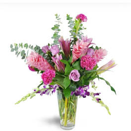 Pink and purple mixed flowers arranged in a clear glass vase