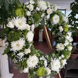White and green floral wreath on a wooden easel