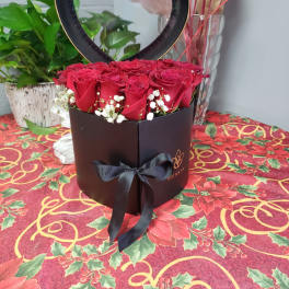 Red roses in a heart-shaped box with a black ribbon