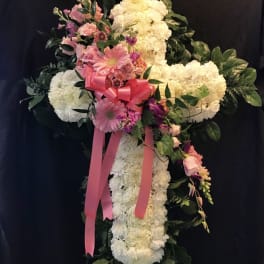 Standing floral cross with pink and white flowers and a pink ribbon