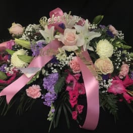 Large pink and white floral spray with ribbons on a black background