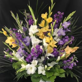 Yellow, white, and purple flowers in a white vase