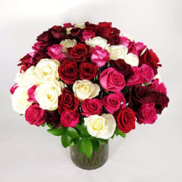 Large bouquet of red, pink, and white roses in a glass vase