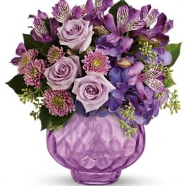 Purple bouquet in a lavender glass vase