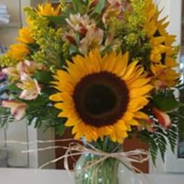 Sunflower bouquet with mixed blooms in a glass vase