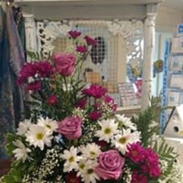 Pink roses and white daisies in a mixed floral arrangement