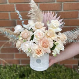 Bouquet of blush and white roses in a white hat box