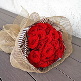 Bouquet of red roses wrapped in striped paper and burlap mesh
