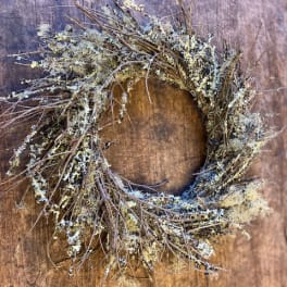 Rustic twig wreath with pale lichen on a wooden background