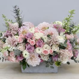 Pastel floral arrangement in a rectangular gray vase