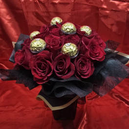 Bouquet of red roses with gold-wrapped chocolates