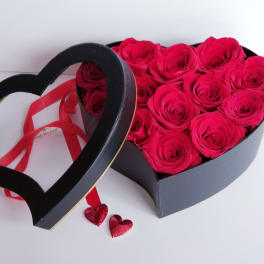Heart-shaped box of hot pink roses with a ribbon and heart decorations