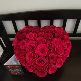 Heart-shaped bouquet of red roses on a black chair