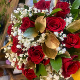 Bouquet of red roses with white baby's breath and gold leaves