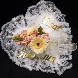 Lace-wrapped bouquet with pink and yellow flowers and gold script