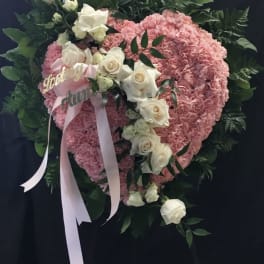 Pink heart-shaped floral wreath with white roses and ribbon